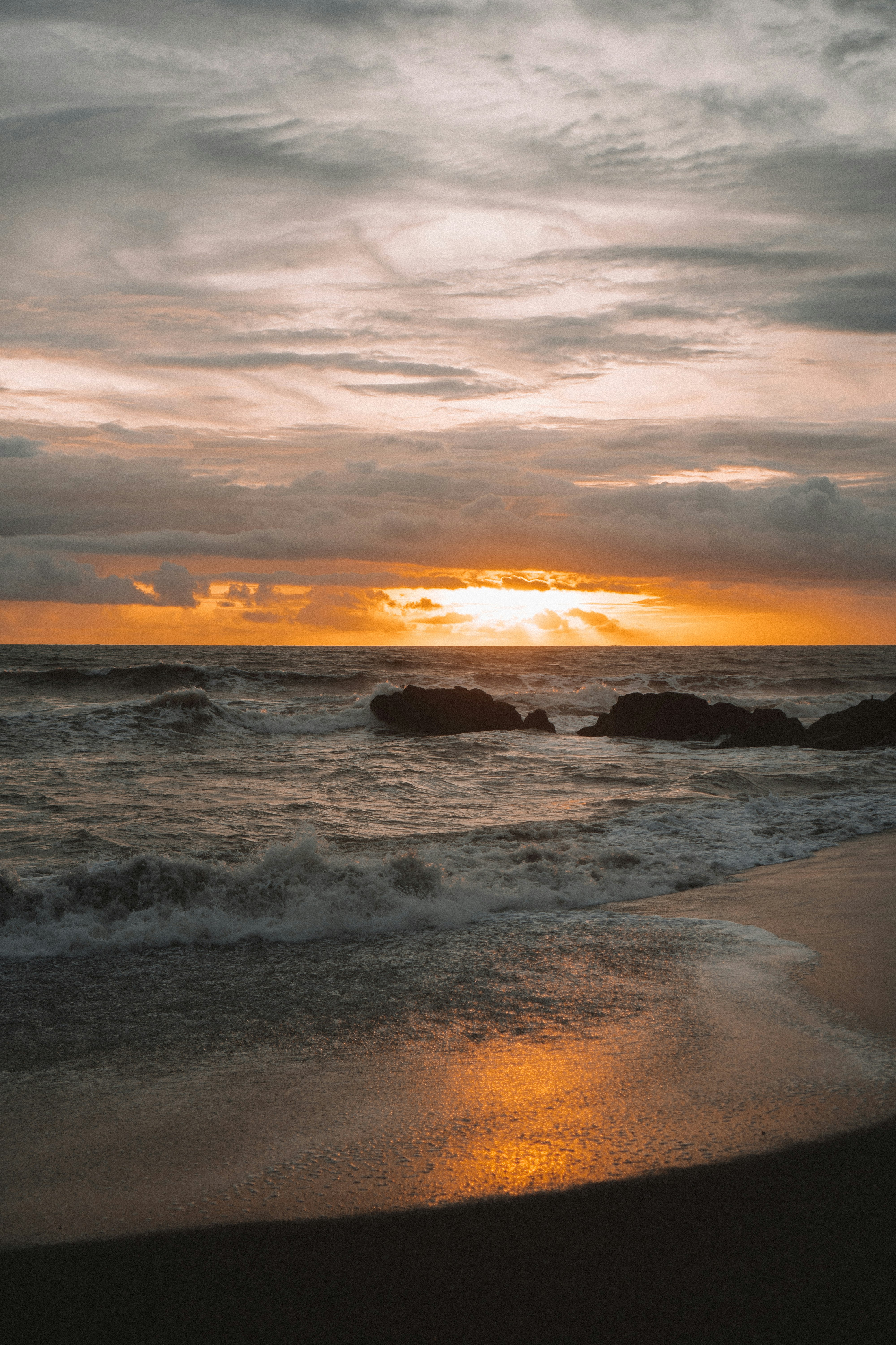 sea waves crashing on shore during sunset